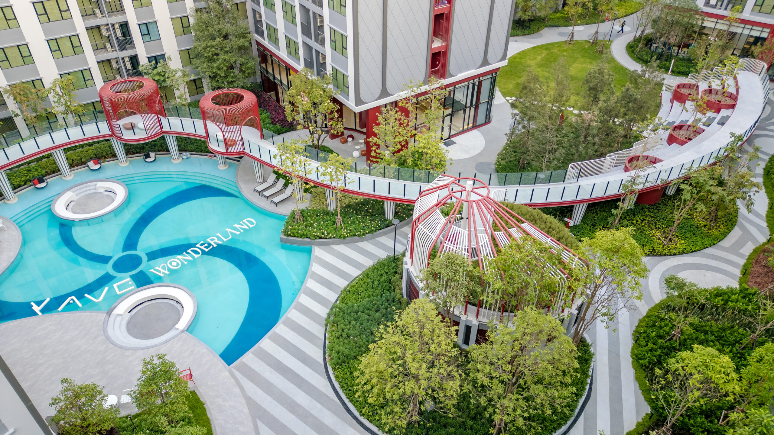Pool ยาวกลางโครงการ + walkway โค้งสีแดง
