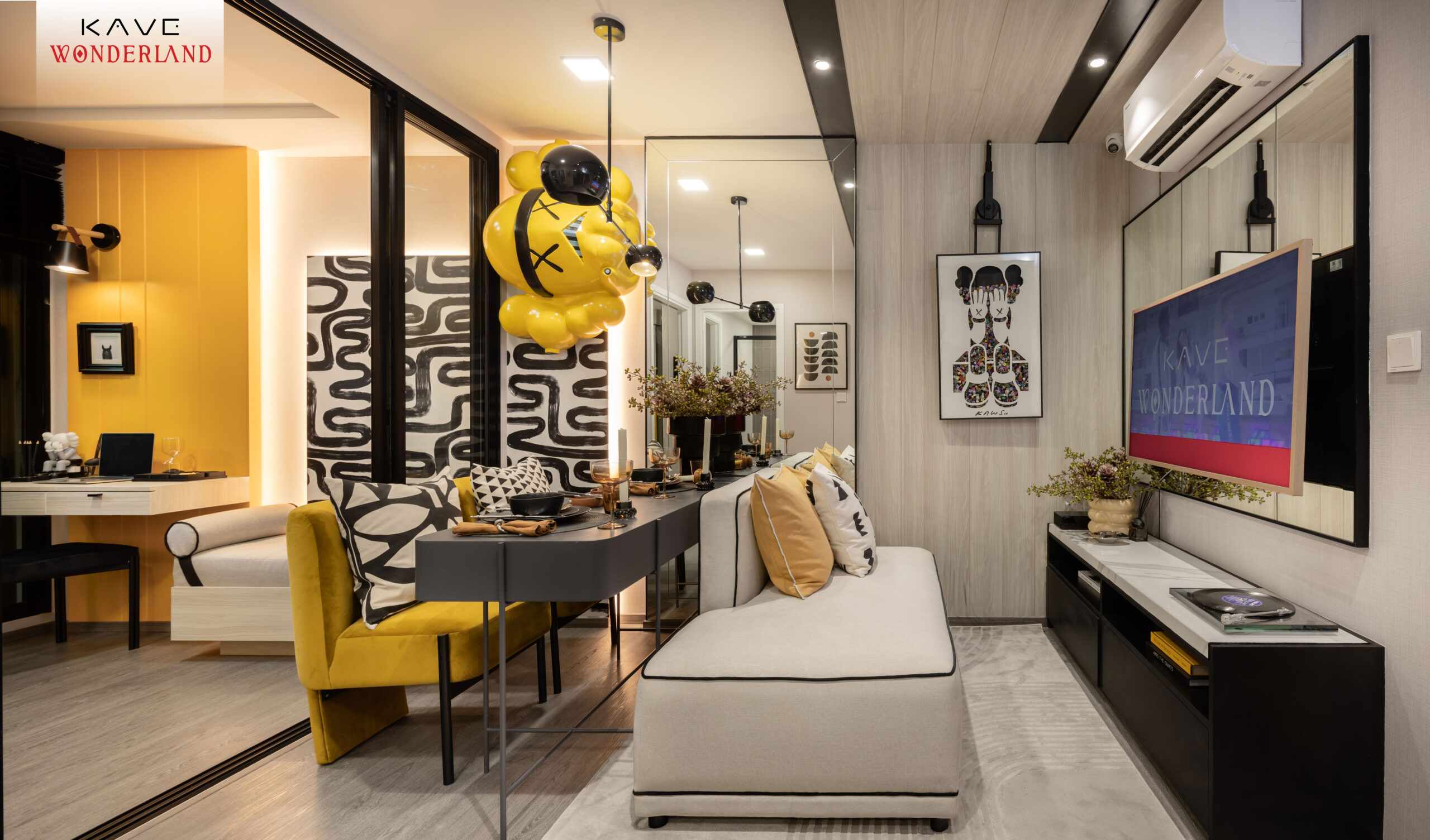 1BR Plus — ห้องนั่งเล่น (Theme สีเหลือง+ดำ + KAWS-style figure)